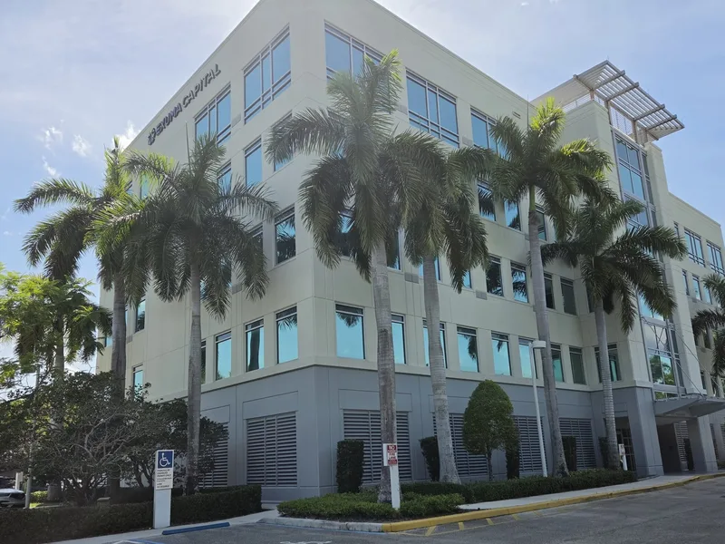 Four-story office building at 1250 S Pine Island Rd, Plantation, Florida, with Exuma Capital signage and palm trees